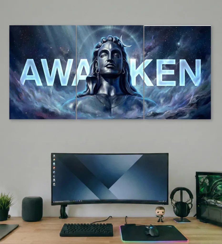 Awaken Shiva triptych poster above a modern gaming desk with curved monitor.